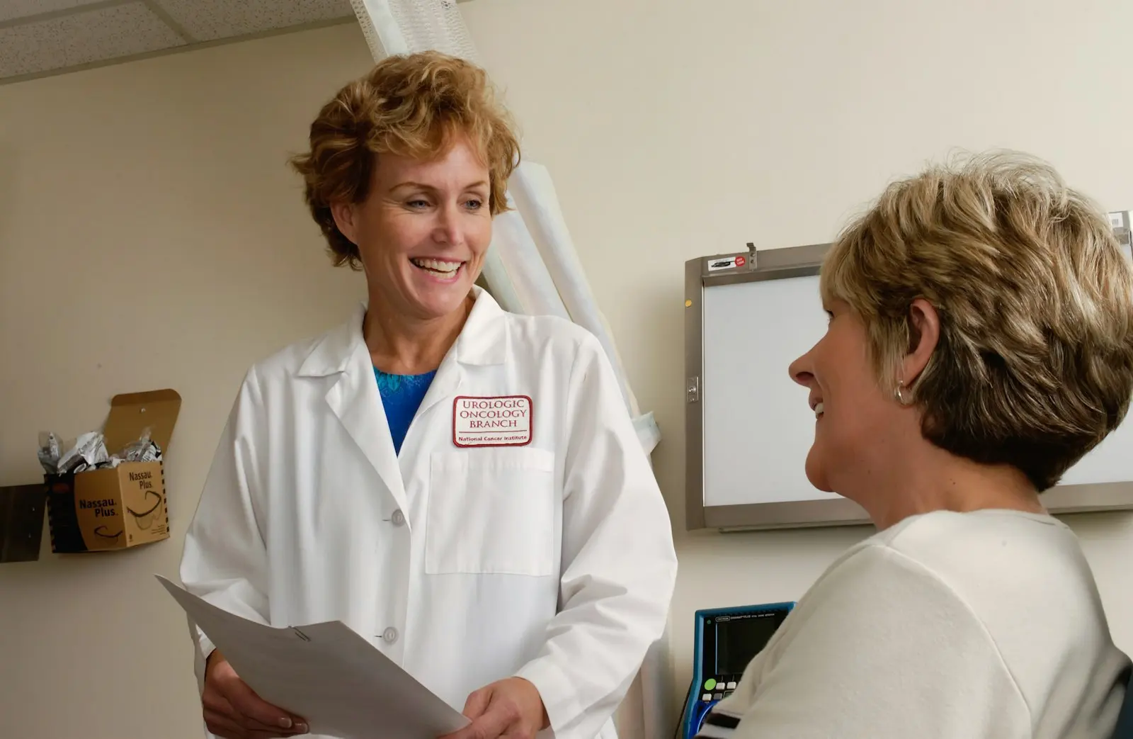 Two clinicians in white coats talking in a hospital