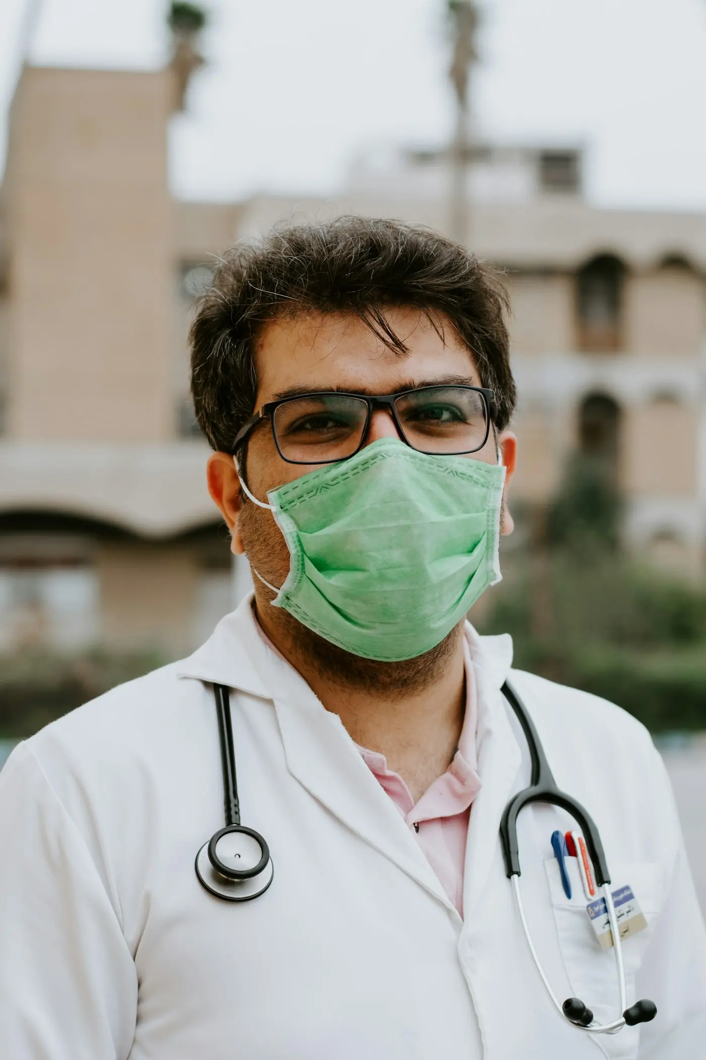 A doctor in a surgical mask in a hospital corridor