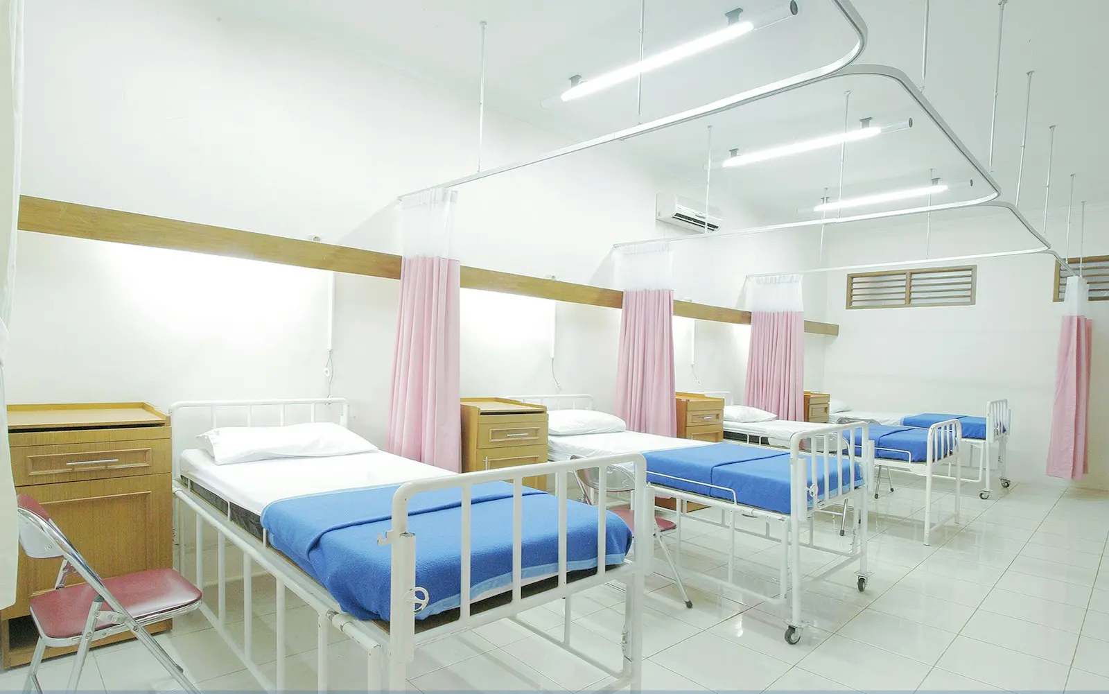 An empty hospital ward with made beds